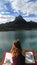 Girl viewing absorbed the lake and the mountain peak