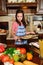 Girl with a vintage haircut in the kitchen among vegetables with a tray with baked cookies