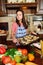 Girl with a vintage haircut in the kitchen among vegetables with a tray with baked cookies