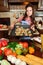 Girl with a vintage haircut in the kitchen among vegetables with a tray with baked cookies