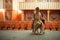 Girl in a vintage style sits in a retro dress on the stage of an empty theater. In the background, an empty auditorium