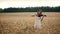 Girl violinist playing the violin in wheat field.