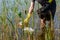 Girl volunteer cleans the pond from garbage