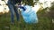 Girl volunteer picks up trash in a suburban park. Stop plastic, plastic pollution of the planet, social concept