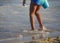 Girl wading in the waves, close up, with the water up to her ankles