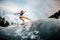 Girl wakesurfer makes stunts on a board