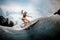 Girl wakesurfer performs stunts on a board
