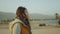 Girl walk on beach and looking Into Horizon. View of sand beach and blue sea from back of female, slow motion, 4k