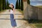 Girl is walking along the road among the fields