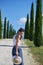 Girl is walking along the road among the fields