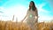 Girl is walking along the wheat field nature slow motion video. Beautiful girl in white dress running nature freedom