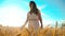 Girl is walking along the wheat field nature slow motion video. Beautiful girl in white dress running nature freedom