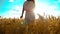 Girl is walking along the wheat field nature slow motion video. Beautiful girl in white dress running nature freedom