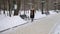 Girl walking along the winter alley with coffee.