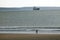 Girl Walking on Beach with Tanker Behind