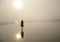 Girl walking on beautiful foggy beach.