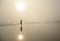 Girl walking on beautiful foggy beach.