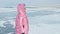 Girl walking on cracked ice of a frozen lake Baikal. Woman trave