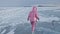 Girl walking on cracked ice of a frozen lake Baikal. Woman traveler explores and looks at an ice floe. It is magical