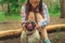 Girl walking with a dog breed pug in the Park. Pug resting in the woods