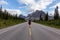 Girl walking down a scenic road in the Canadian Rockies