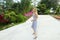 Girl walking in exotic park near plams and flowers.