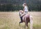 Girl walking in the field on her Sabino paint horse