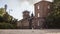 A girl walking outside of a red brick military building at Suomenlinna fortress island in Finland