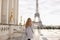 Girl walking on Trocadero square near gilded statues with Eiffel Tower background, Paris.