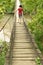 Girl walking on a wooden bridge over a river