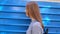 A girl walks along a blue background- railway car
