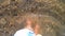 Girl walks barefoot on a sandy bottom with stones of the sea shore