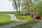 Girl walks down spring lane with flower and wagons