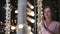 A girl walks through the evening Dubai among luminous palm trees.