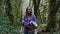 Girl walks in the mysterious forest among the moss-covered trees.