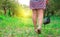 A girl walks in the park in the rays of the setting sun in silver ballet shoes and a dress with an ornament