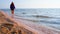 A girl walks on the sand on the seashore