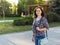 Girl walks in the summer park. Brunette girl in the city center