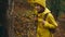 girl walks on trail with thicket and and fallen trees. slow motion attractive young Woman hiker in yellow raincoat and