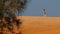 Girl Walks on White Sand Dune Crest on Skyline