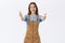 Girl wants give warm friendly hug. Portrait of charming gentle and cute european female in brown overalls over blue t