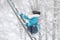 A girl in warm clothes and a hat walks in a snow-covered winter park