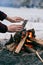 Girl warms hands near a fire in winter