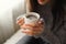 The girl warms her hands on a coffee mug close-up