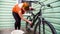 A girl washes a bicycle near the house