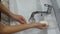 Girl washes her hands with soap in a washroom, close-up