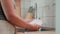 a girl washes a plate with a washcloth under water