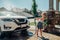 Girl washing car on driveway in front house on sunny summer day