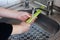 Girl is washing celery leaf under pouring water in the sink in the kitchen. Concept of hygiene, cleanliness