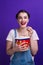 Girl watch favorite comedian tv show, hold popcorn bucket, isolated purple violet background